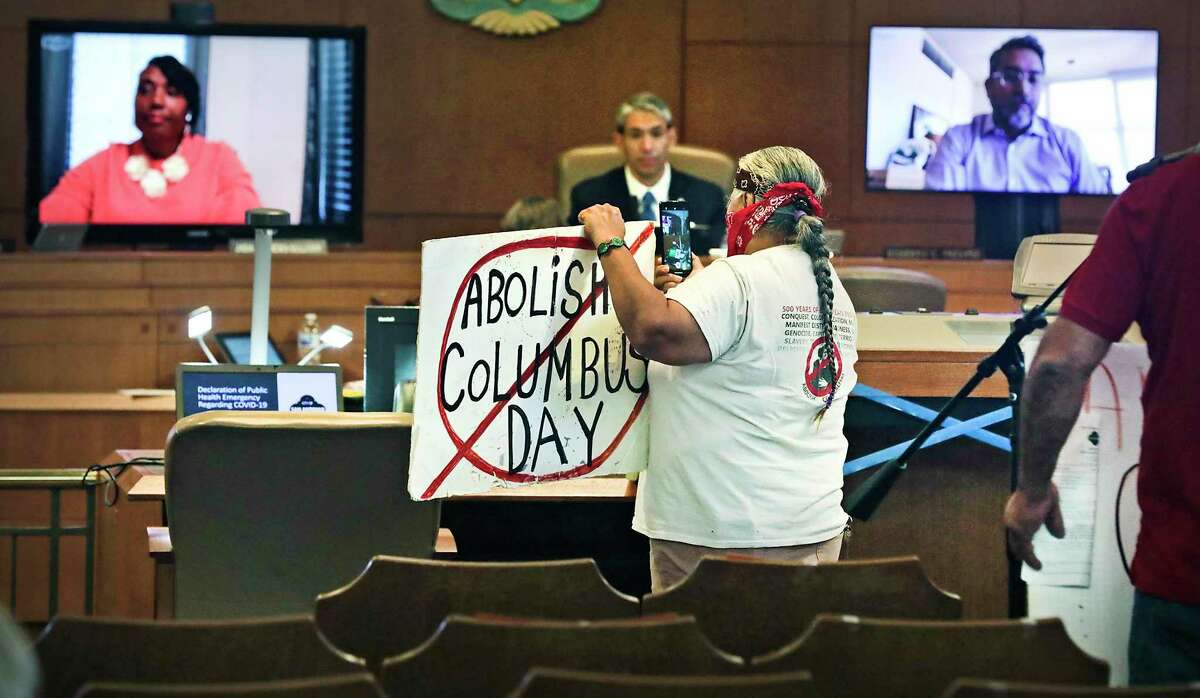 Diana Uriegas holds a protest sign as the San Antonio City Council meets at the Municipal Plaza Building on Thursday, June, 11, 2020.