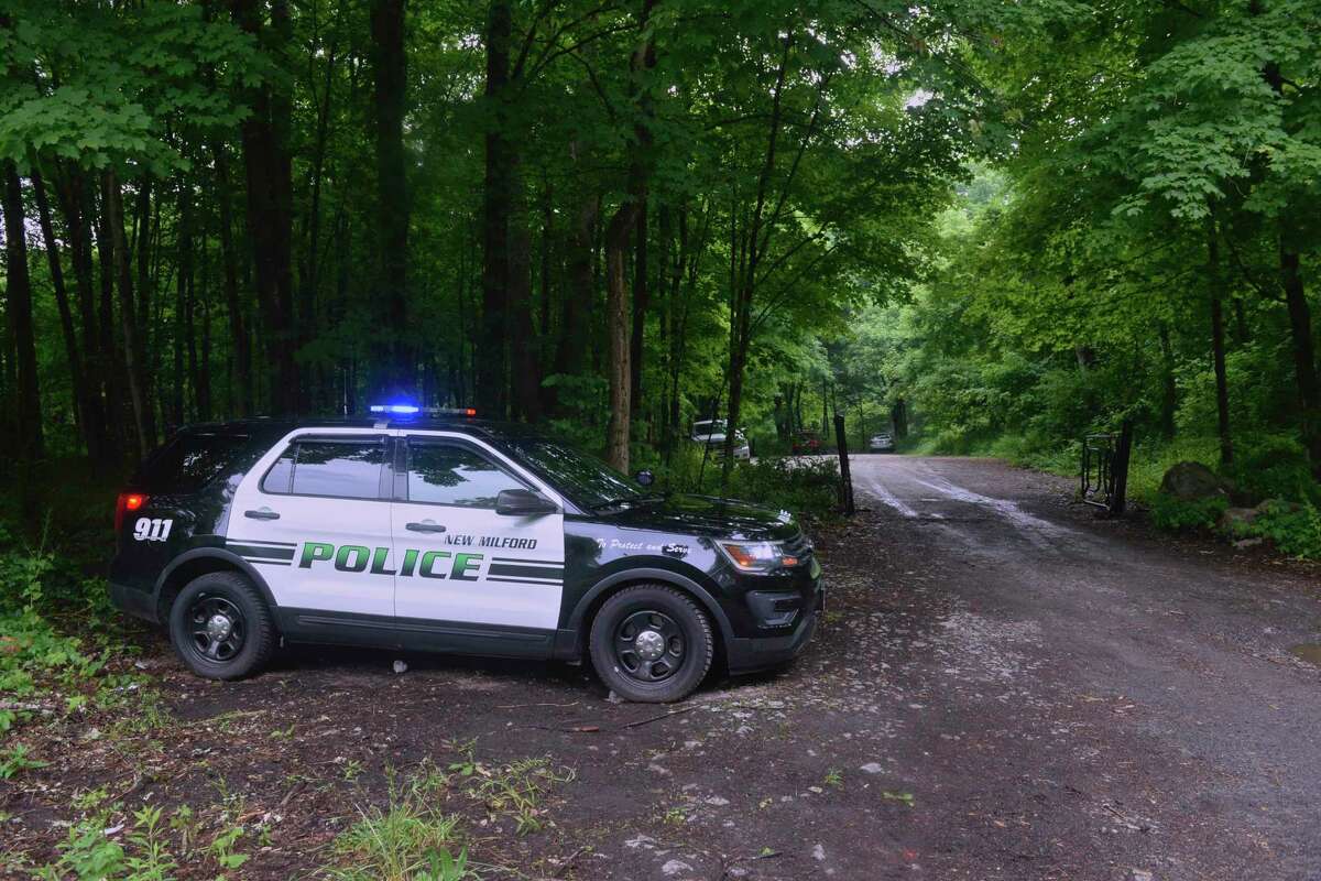 A New Milford police cruiser sits at the entrance to a parking area off Route 7 in Kent for the First Light Bulls Bridge Recreation Area. After hours of searching the day before, dive teams and first responders were back out scouring the river Thursday for the 21- and 24-year-old New York men, who went missing Wednesday while swimming in the Housatonic River. June 11, 2020, in Kent, Conn.