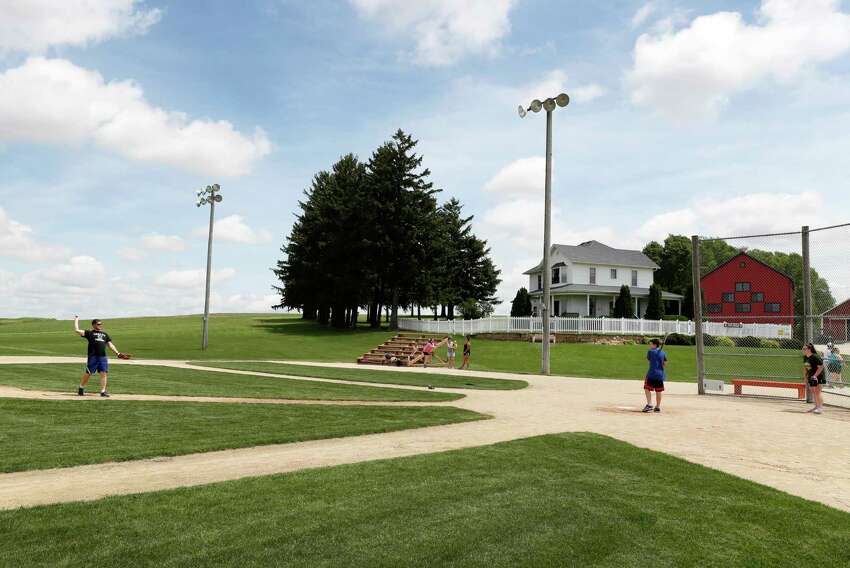 Visitors play on the field at the Field of Dreams movie site, Friday, June 5, 2020, in Dyersville, Iowa. Major League Baseball is building another field a few hundred yards down a corn-lined path from the famous movie site in eastern Iowa but unlike the original, it's unclear whether teams will show up for a game this time as the league and its players struggle to agree on plans for a coronavirus-shortened season. (AP Photo/Charlie Neibergall)