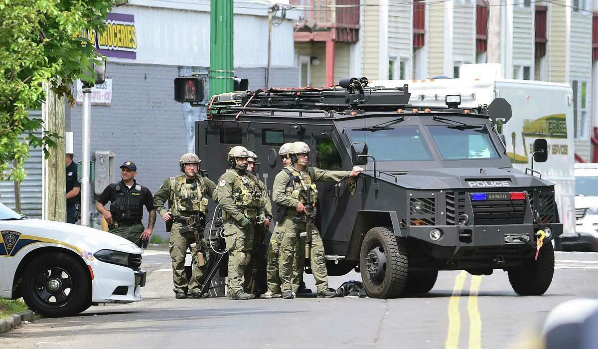 New Haven Police wait behind an armored vehicle in the aftermath of a hostage situation in New Haven on June 4.