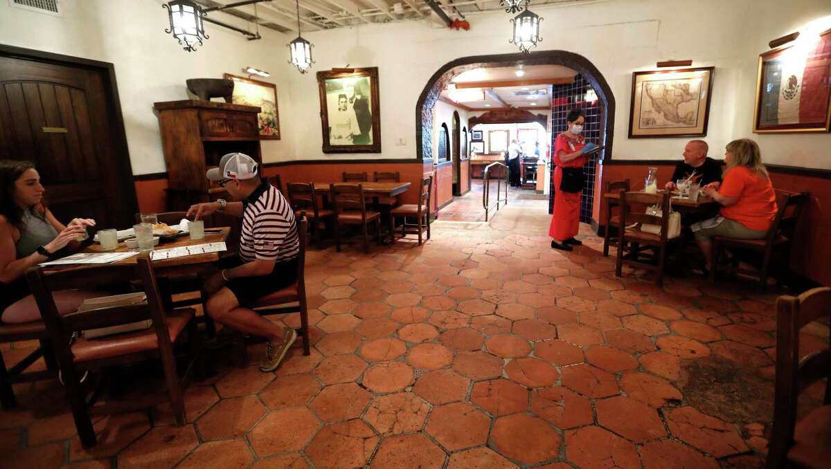 Kady Lopez, a server at the Original Ninfa's on Navigation Drive, takes an order from Chris and Kathy Schultz, of Pearland in the dining room of Ninfa's, in Houston, Friday, May 1, 2020. Since restaurants were allowed to reopen in May, after being forced to close due to local shutdown orders to slow the spread of the coronavirus, economic activity has begun to show signs of creeping back. But, experts say restaurants may struggle through 2020 as some customers may not feel comfortable to dine-in for some time.