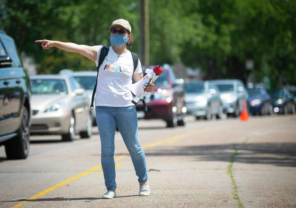 Southwest Management District executive director Alice Lee directs traffic during a food distribution at Bush Elementary on Saturday, June 6, 2020. SWMD partnered with several organizations to give away 500 food kids to registered citizens.