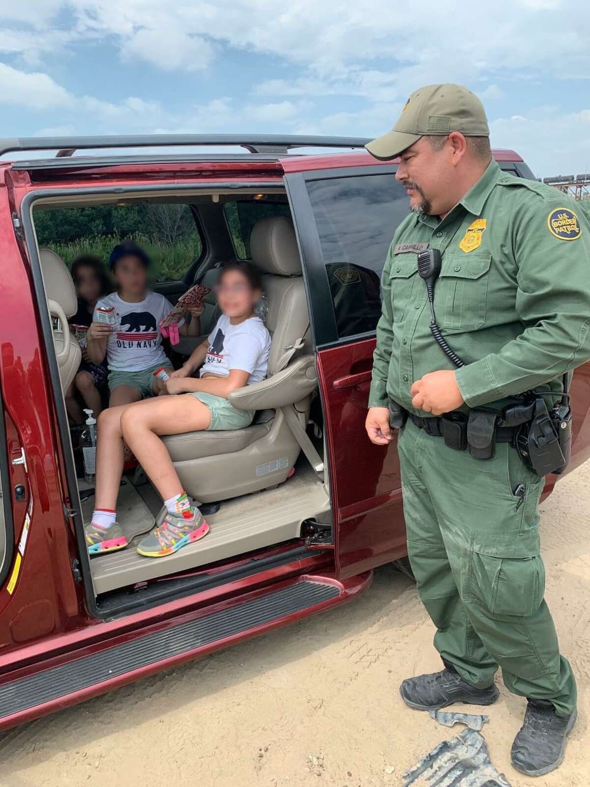 U.S.. Border Patrol Agent Ricardo Carrillo, a certified EMT, stands next to the children he rendered aid to. Carrillo provided medical attention to one girl who was suffering from severe heat exhaustion.