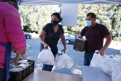 Teresa and Mauricio De Sosa of Oakland pick up meals at the food distribution site at Esperanza Elementary School.
