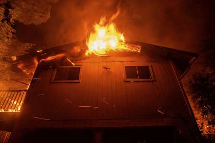 Flames consume a home as the Quail Fire burns near Winters (Yolo County) this month.