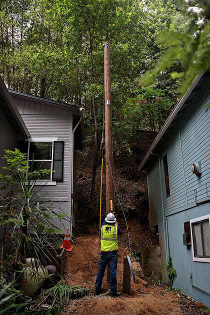 A PG&E crew replaces older wood power poles at Guerneville’s Odd Fellows Park with more resilient ones that are less likely to break during windstorms and cause wildfires.
