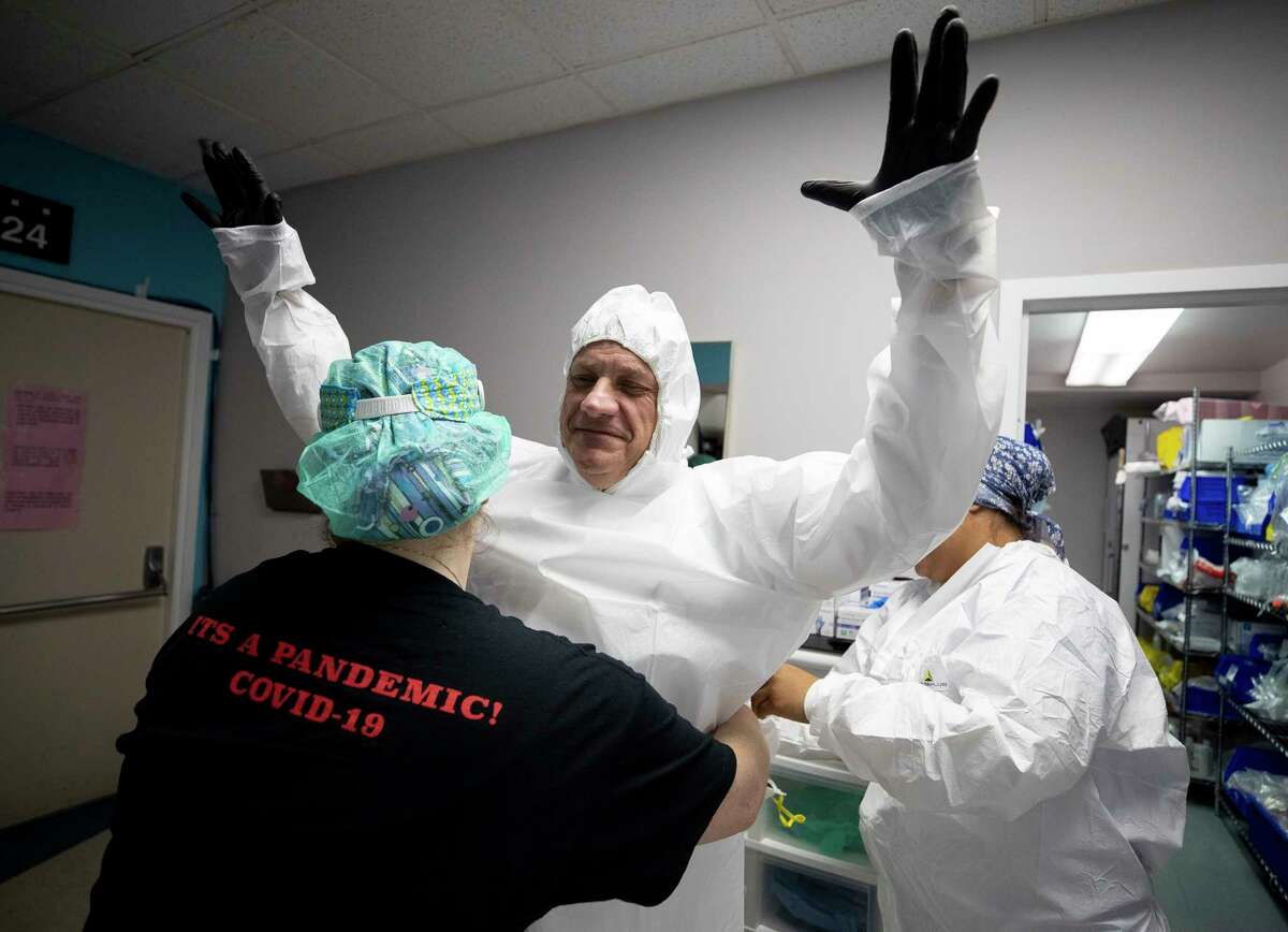 Dr. Joseph Varon, center, and his medical staff get into PPE before heading going inside the COVID-19 intensive care unit at United Memorial Medical Center on Thursday, June 11, 2020, in Houston. The state of Texas has seen a spike in COVID-19 cases.