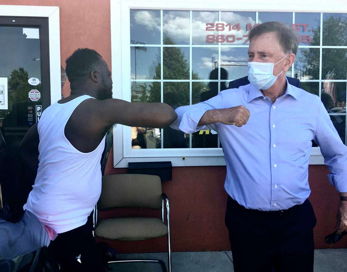 Gov. Ned Lamont took a walk in Hartford's North End Friday to talk with small business owners about the coronavirus crisis. He's pictured bumping elbows with Kenston Harry, owner of The Action Audio Store.