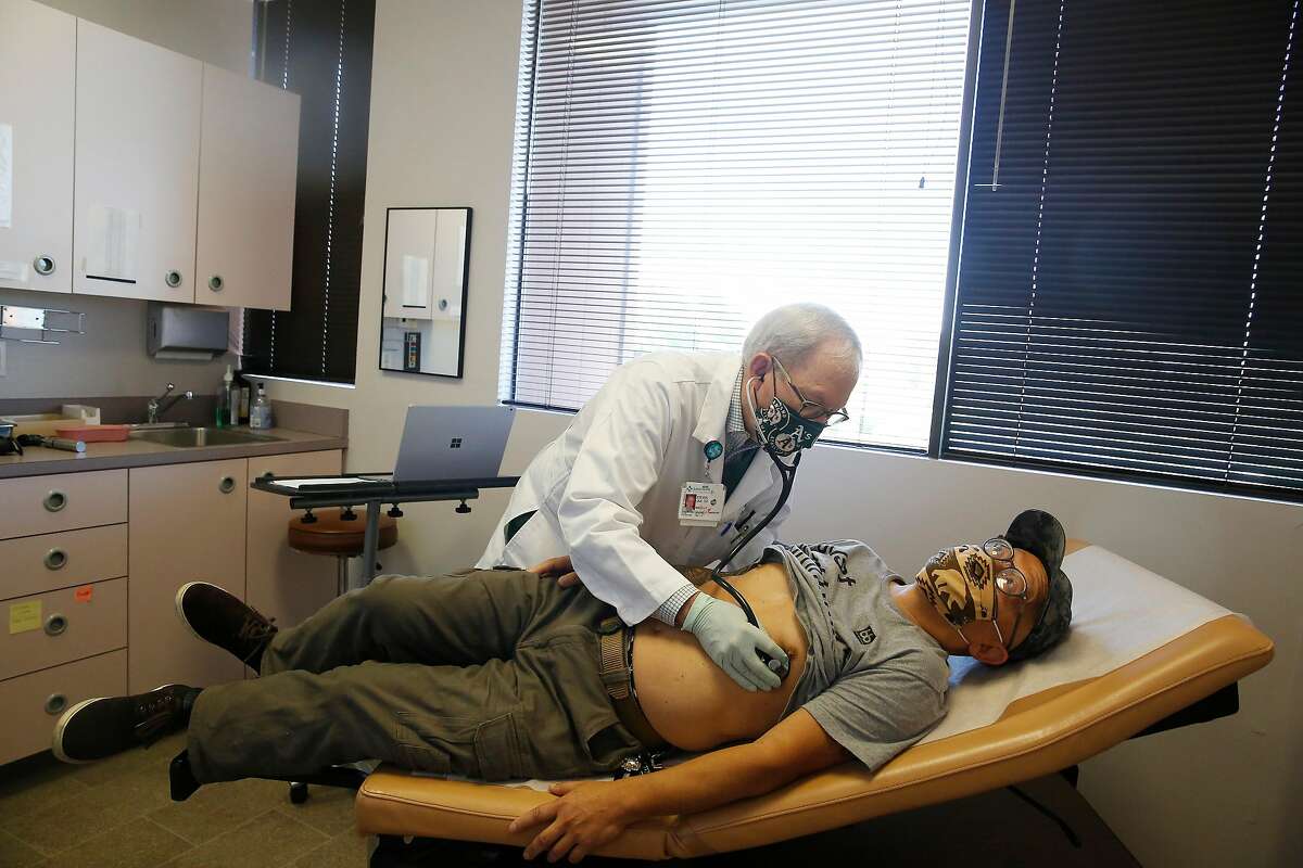 Dr. Steven Una (top) performs an auscultation on patient Gary Yen (bottom), of Castro Valley, during a visit at Una’s office on Monday, June 1, 2020 in Castro Valley, Calif.