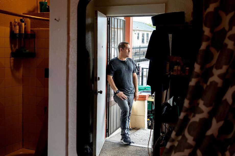 Rafael Arias poses in the doorway of his home in Oakland after recovering from the coronavirus. Photo: Jessica Christian / The Chronicle