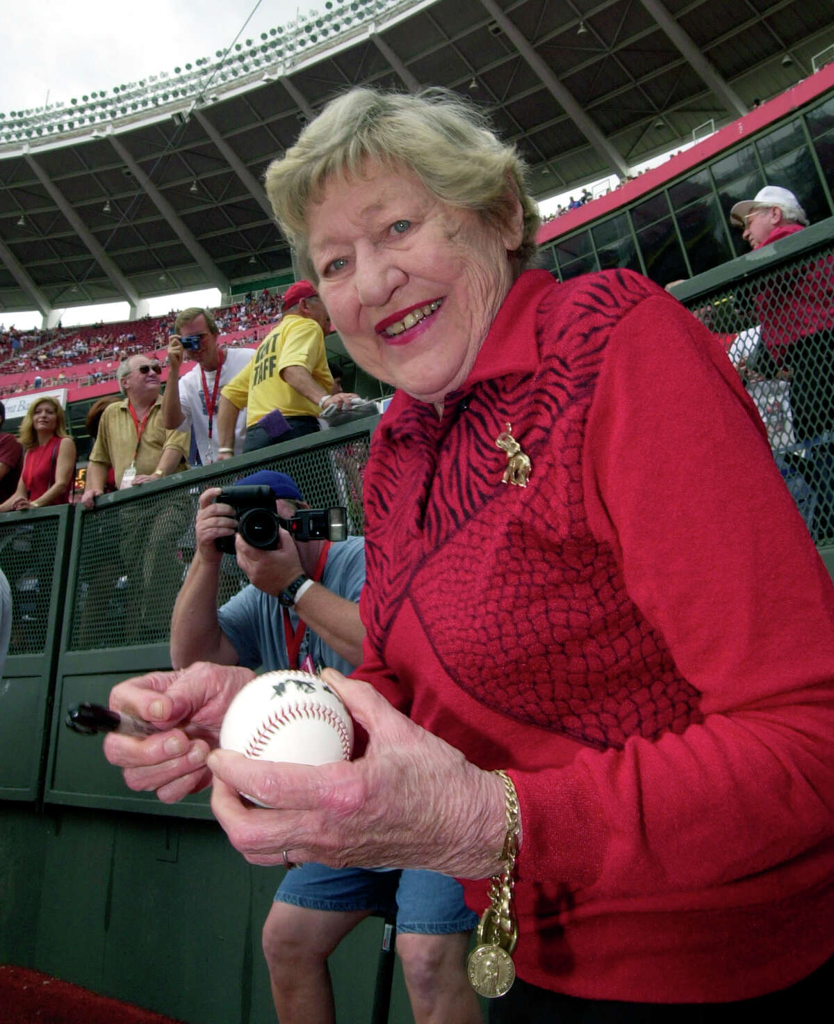 FILE - In this Sept. 22, 2002 file photo former Cincinnati Reds majority owner Marge Schott signs autographs prior to the final game at Cinergy Field in Cincinnati. Schott was a divisive figure when she owned the Cincinnati Reds, getting suspended and ultimately forced out for her racially offensive language. The community is debating what to do with facilities named in her memory. (AP Photo/David Kohl, file)
