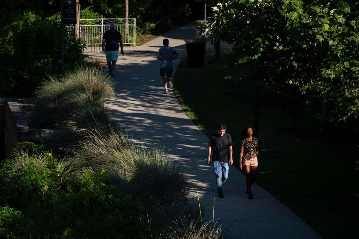 People walk along the San Antonio River at the Blue Star Arts Complex on June 12, 2020. The city of San Antonio has logged nearly 700 new cases of the novel coronavirus since Saturday, June 6, and hospitalizations have reached an all-time high.
