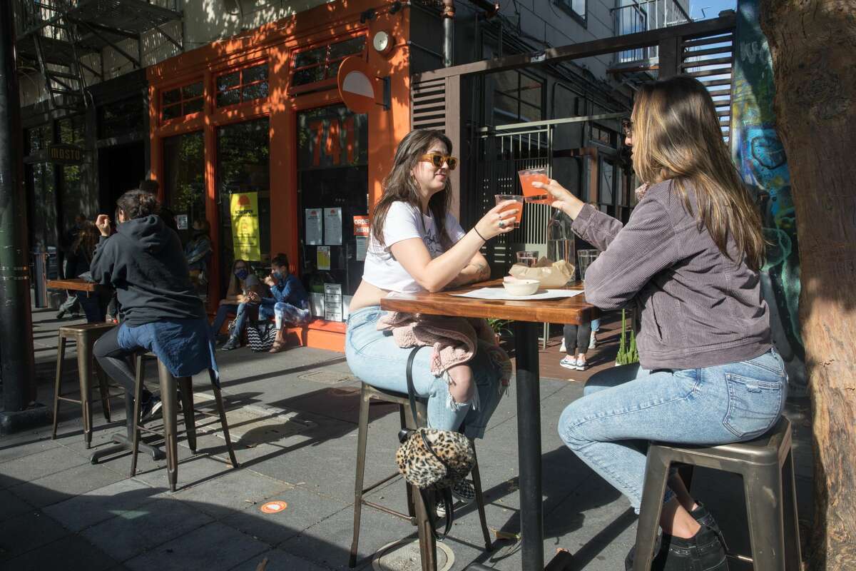 California's economy began reopening on May 8. (Left to right) Haylie Aitken and Rachel Pratley enjoy a margarita atTacolicious on Valencia Street in San Francisco, Calif.. The restaurant started offering outdoor food service on June 12, 2020.