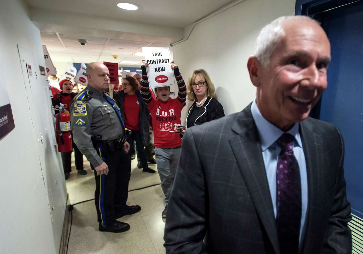 Shouting for a fair contract, students and faculty from Connecticut State Universities stand at the entrance to the Connecticut Board of Regents board room Thursday, Dec. 3, 2015, as Board of Regents/CSCU System President Mark E. Ojakian enters the room for a meeting of the regents.
