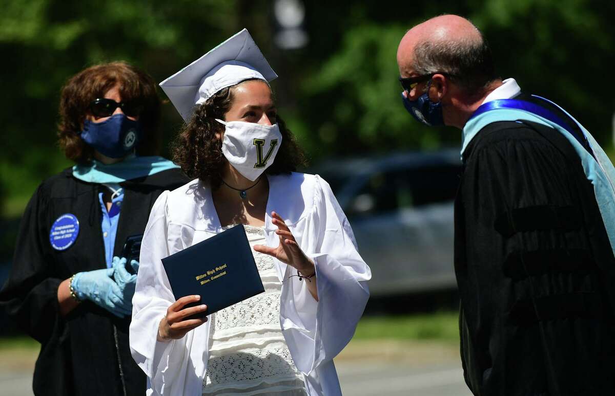 Graduates including Kailey Titus arrive by motorcade at the Wilton High School commencement ceremoniy Saturday, June 13, 2020, in Wilton, Conn.