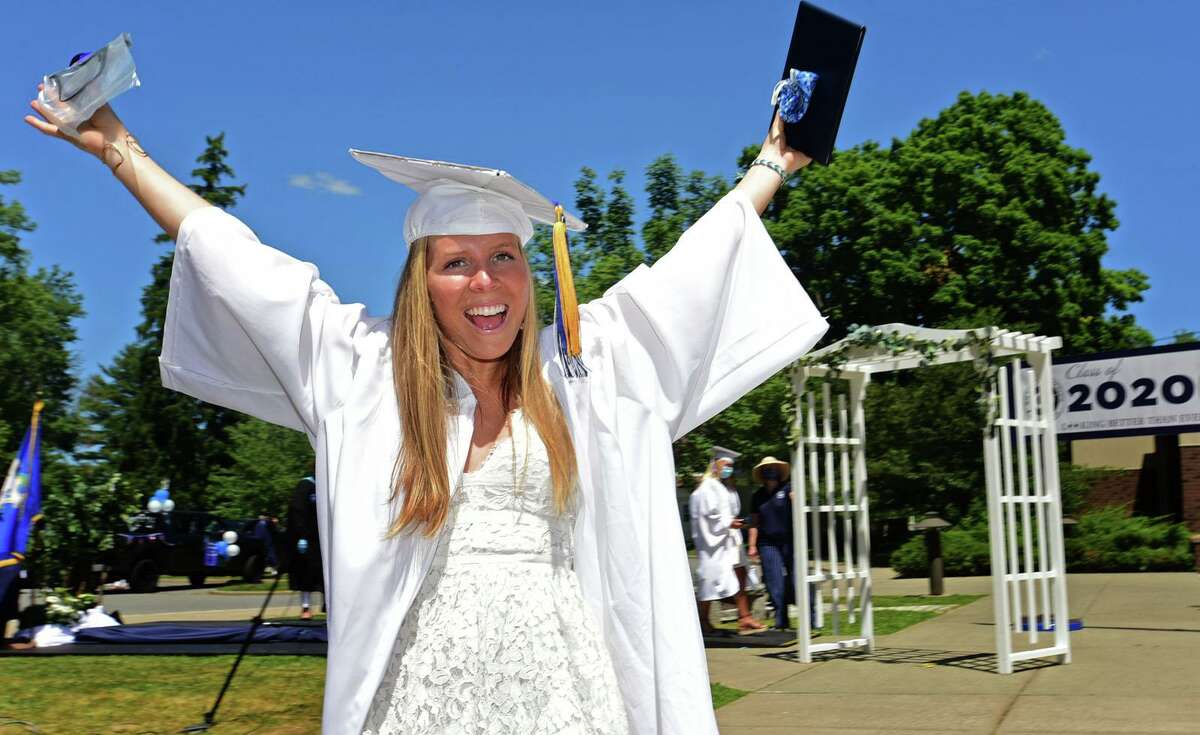Graduates including Kayla Cohen arrive by motorcade at the Wilton High School commencement ceremony Saturday, June 13, 2020, in Wilton, Conn. Maintaining social distancing, at two separate locations, students were able to exit their cars, receive their diploma covers from school officials, and turn their tassels to mark graduation. The entire event was televised live as well.