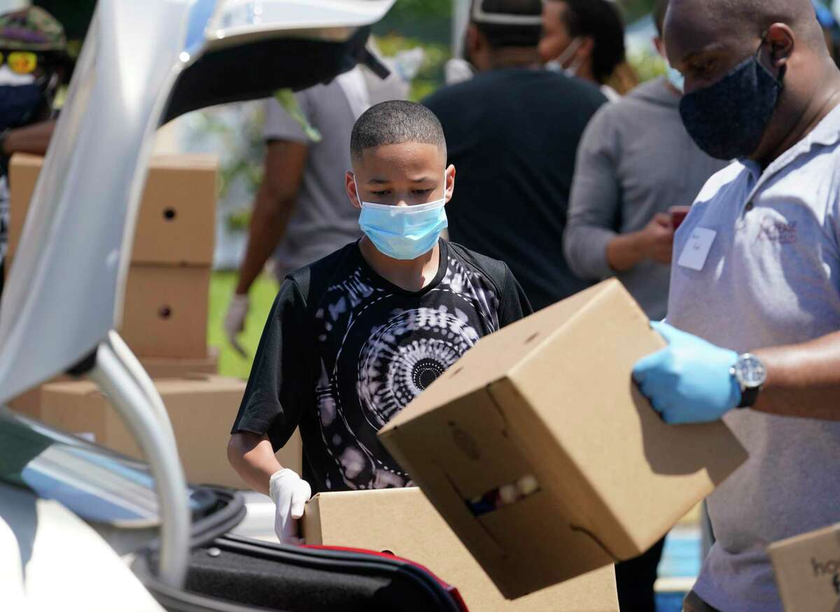 Darnell Joseph, 13, and other volunteers load boxes into a car during a COVID-19 essentials distribution at Missouri City Baptist Church, 16816 Quail Park Drive, Saturday, June 13, 2020, in Missouri City. Food, masks, hand sanitizer and educational materials were distributed at the joint event presented by Mayor Sylvester Turner’s Health Equity Response (H.E.R.) Task Force Medical Care Subcommittee and the Houston Medical Forum.