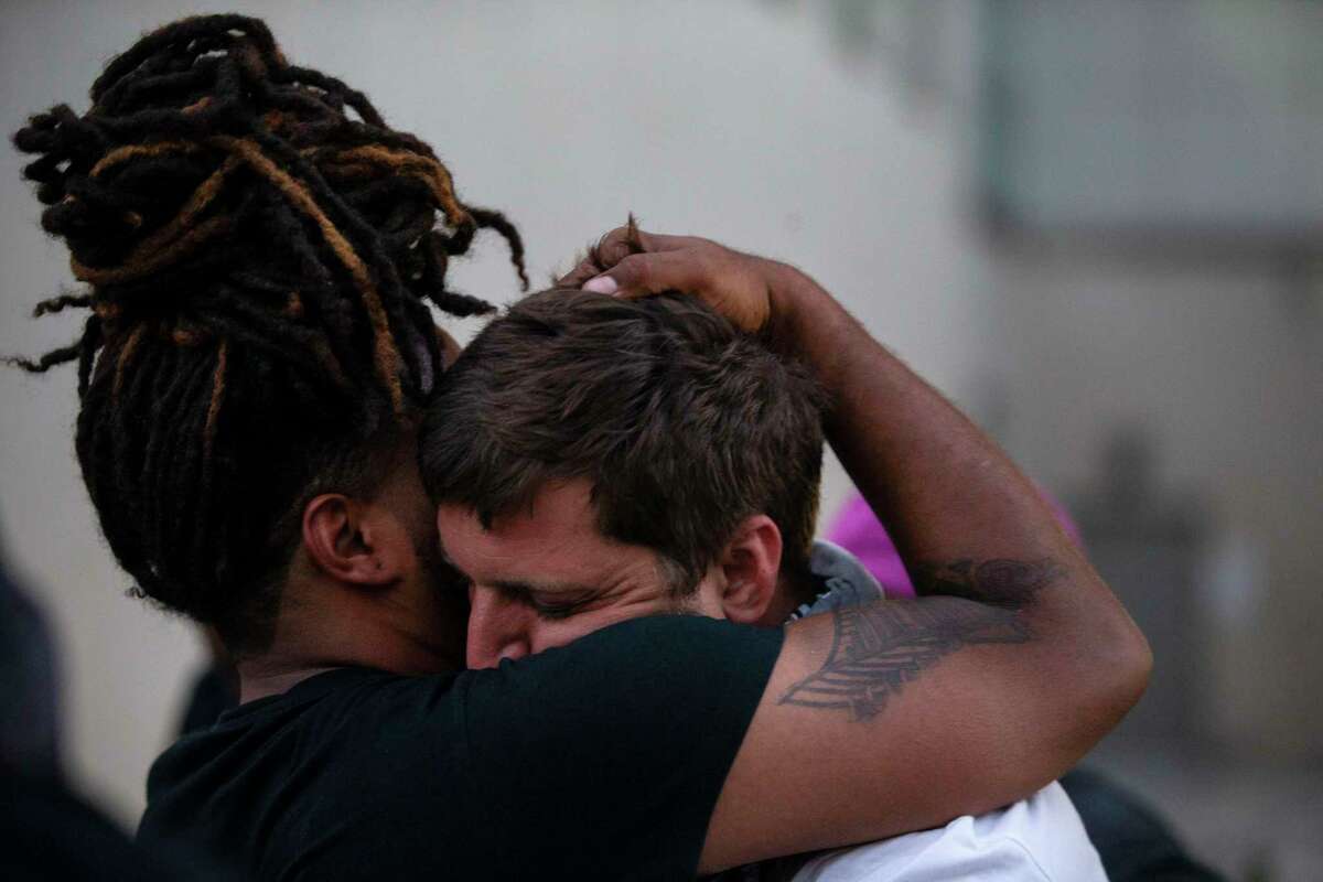 Antonio Lee embraces Brandon Mowles after Mowles was released from being detained on suspicion of vandalism outside Public Safety Headquarters in downtown San Antonio on June 3, 2020.