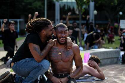 Antonio Lee, left, comforts Trevor Taylor during an emotional moment at a demonstration held at Travis Park in downtown San Antonio on June 3, 2020.