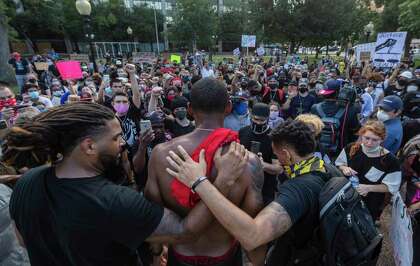 Trevor Taylor, center, is comforted as he talks about his experiences as a black man during a demonstration June 3, 2020, at Travis Park in downtown San Antonio. Taylor was part of a rally protesting the death of George Floyd. Floyd died in police custody May 25, 2020, in Minneapolis. His death has inspired protests worldwide against racism and police violence.