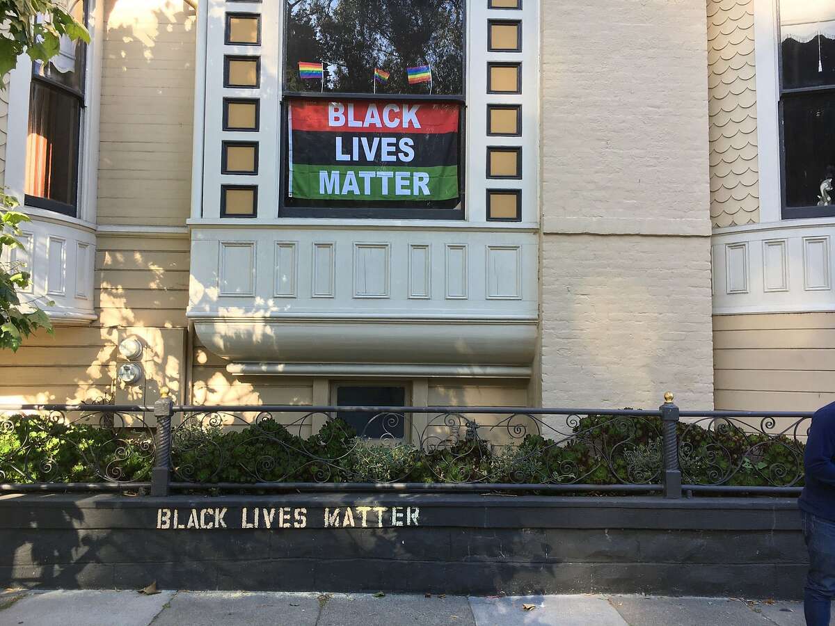 The words Black Lives Matter are stenciled on a retaining wall in and shown in the window of a house the Pacific Heights neighborhood of San Francisco, Calif., on Saturday, June 13, 2020.