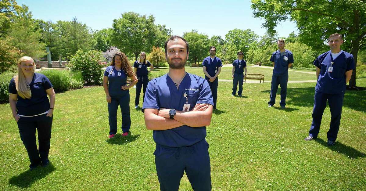 Dr Essam Nagori, center, with fellow graduates in the gardens at Greenwich Hospital following a graduation ceremony for Internal Medicine Residency Program doctors.