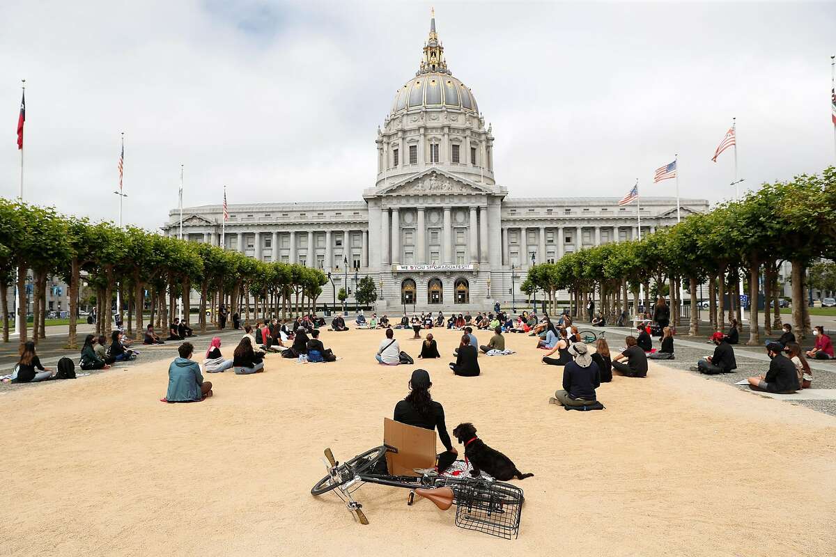 Lisa Denise Velasquez meditates next to her dog, Milo, as she joins Buddhists as they gather in Civic Center for Sit. Walk. Listen. Because Black Lives Matter event in San Francisco, Calif., on Sunday, June 14, 2020.