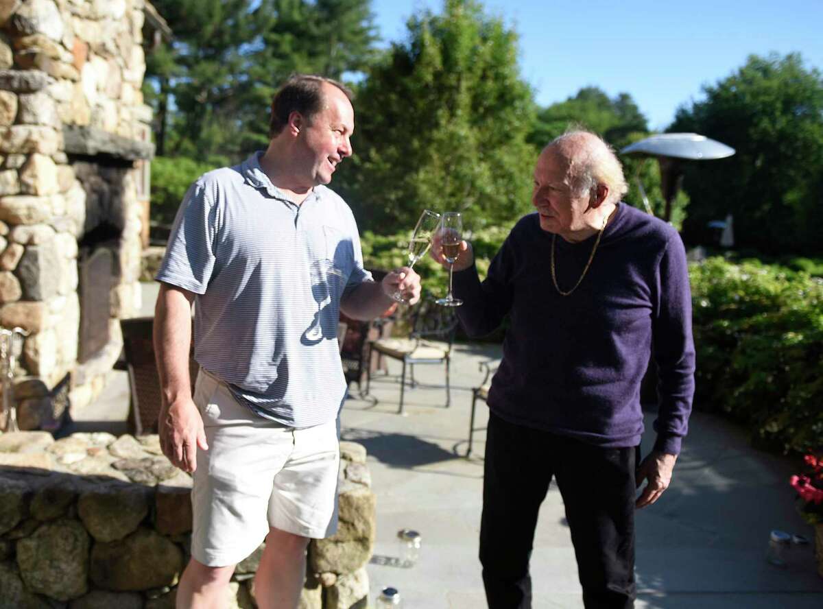 Coronavirus survivor Henry Woerz, 76, rights, drinks a glass of Champagne with Rowayton's Matt Fry, who donated plasma to save his life, at Woerz' son's home in New Canaan, Conn. Sunday, June 14, 2020. Woerz was in grave condition after three weeks on a ventilator battling COVID-19, and was the first patient to receive plasma as part of a clinical trial at Stamford Hospital.