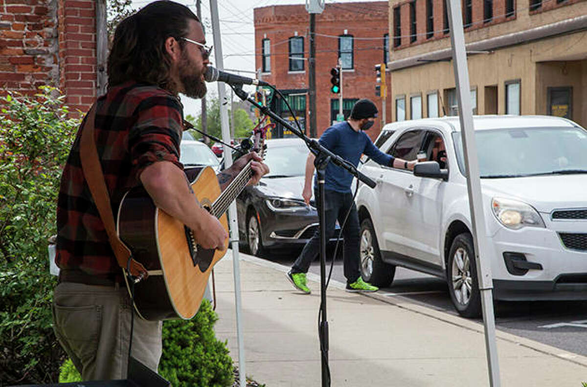 Musician Jared Unfried performs outside between Germania Brew Haus and Jacoby Arts Center in Alton. Although community art and entertainment has been largely absent the past few months because of social gathering limitations, Jacoby Arts Center has returned to the stage with curbside art classes and concerts throughout June.