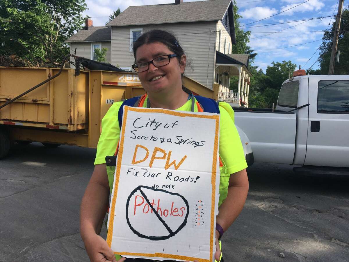 Darlene McGraw and her sign on June 15, 2020 in the driveway on the DPW garage in Saratoga Springs.