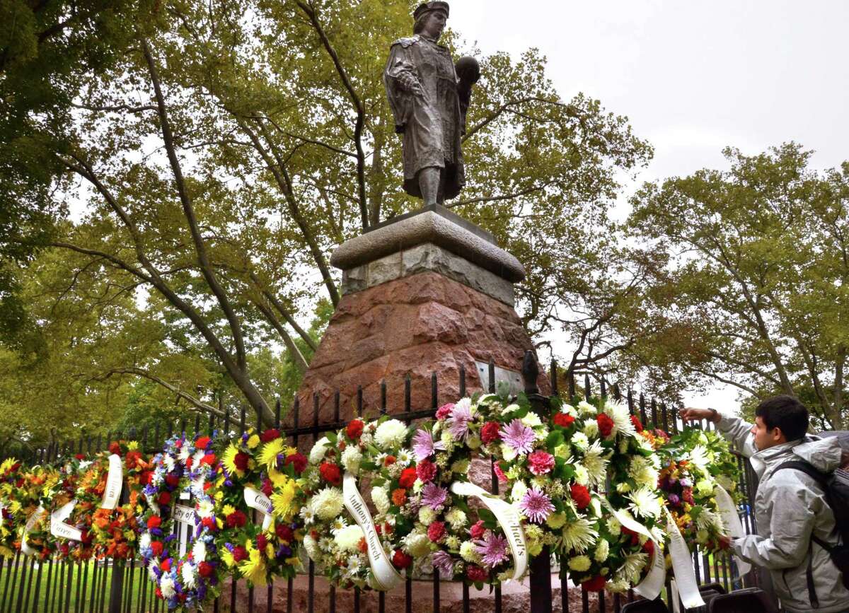 The fencing around the Christopher Columbus statute in New Haven’s Wooster Square is traditionally festooned with wreaths during Columbus Day festivities.