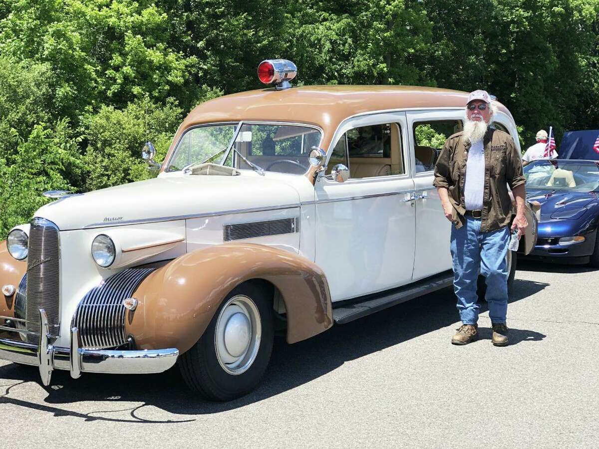 Middletown’s Flag Day part-virtual car cruise took place Sunday afternoon with hundreds of participants watching it online and along the streets of a 3.8-mile loop. Steve Marcolini of Lyme waits for the parade to begin next to his 1939 LaSalle ambulance that he restored.