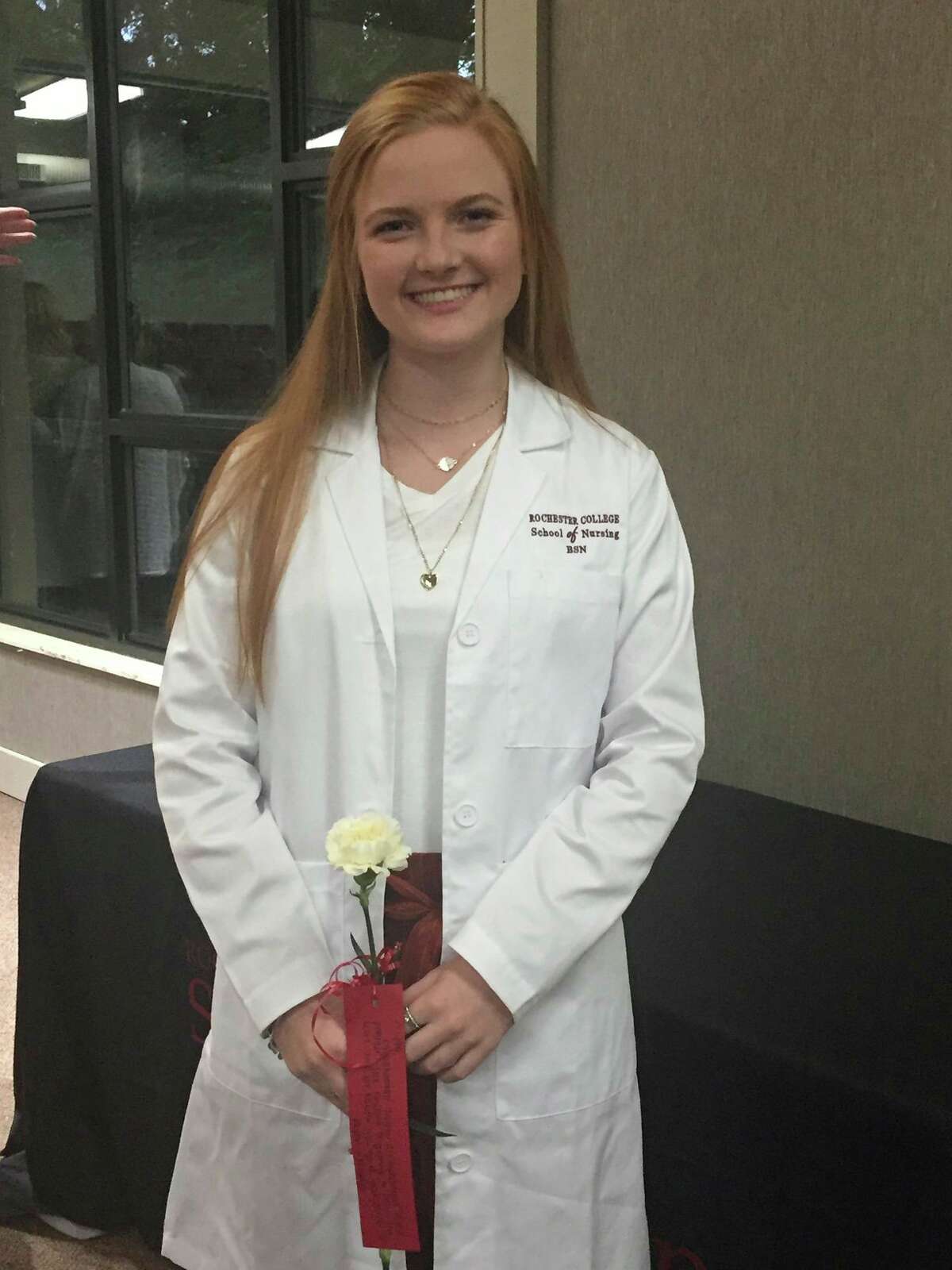 Alli Shea poses in a lab coat at Rochester College.