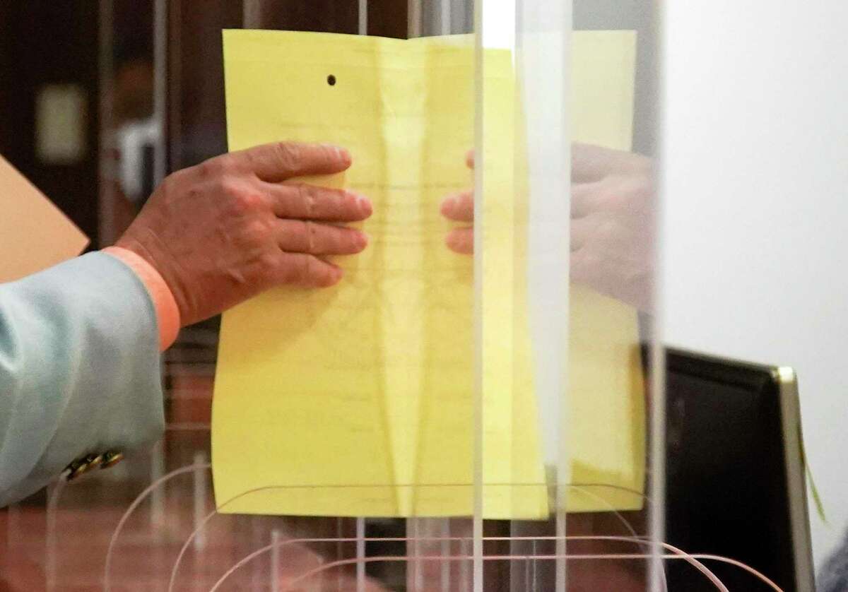 Paper is passed through plexiglass sneeze guard inside a courtroom at the Harris County Courthouse in Houston on Thursday, June 11, 2020.