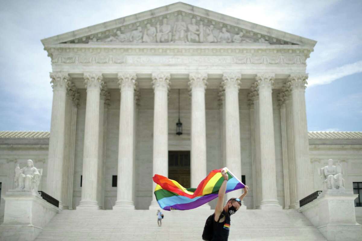 Joseph Fons holding a Pride Flag, walks back and forth in front of the U.S. Supreme Court building after the court ruled that LGBTQ people can not be disciplined or fired based on their sexual orientation June 15, 2020 in Washington. With Chief Justice John Roberts and Justice Neil Gorsuch joining the Democratic appointees, the court ruled 6-3 that the Civil Rights Act of 1964 bans bias based on sexual orientation or gender identity.