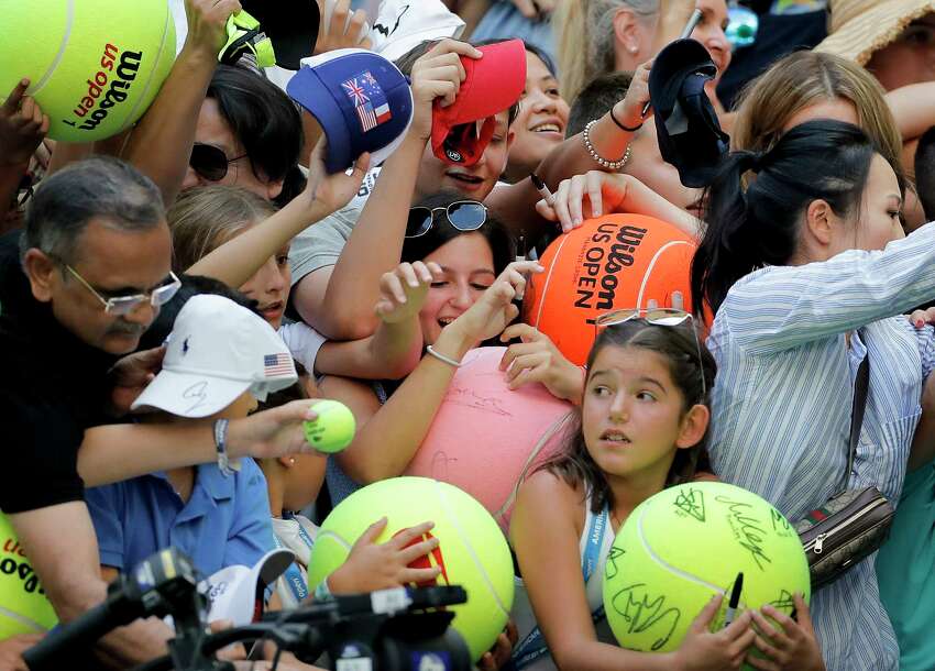 FILE - In this Aug. 31, 2019, file photo, tennis fans crowd the edge of the court hoping for an autograph from Rafael Nadal, of Spain, during round three of the U.S. Open tennis championships in New York. The U.S. Tennis Association intends to hold the U.S. Open Grand Slam tournament in New York starting in August without spectators, if it gets governmental support -- and a formal announcement could come this week. (AP Photo/Eduardo Munoz Alvarez, File)