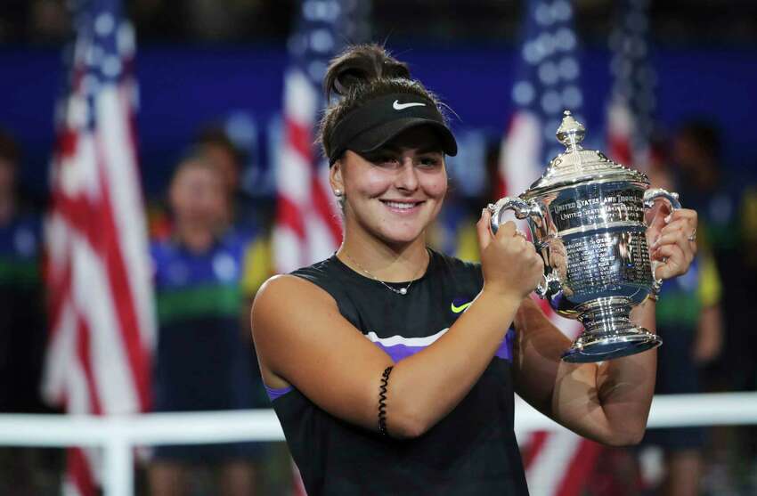 FILE - In this Sept. 7, 2019, file photo, Bianca Andreescu, of Canada, holds up the championship trophy after defeating Serena Williams, of the United States, in the women's singles final of the U.S. Open tennis championships in New York. The U.S. Tennis Association intends to hold the U.S. Open Grand Slam tournament in New York starting in August without spectators, if it gets governmental support -- and a formal announcement could come this week.(AP Photo/Charles Krupa, File)