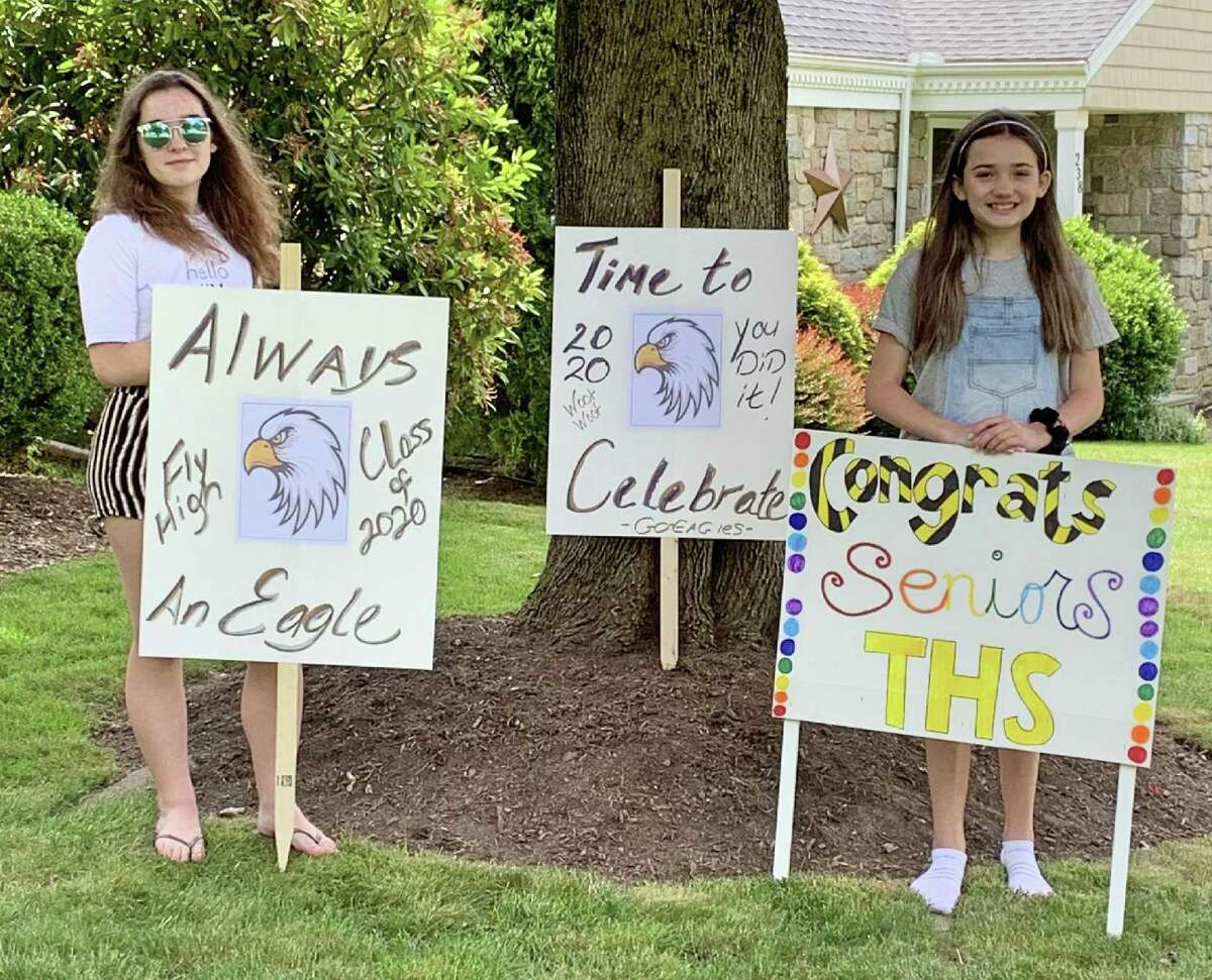 Volunteers have created more than 100 signs to place along the route of the procession route. Here, Brianna Buda, left, and Kate DiGiovanni show some of the signs they made.