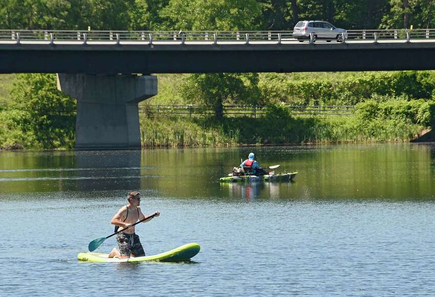 A young man on his paddle board makes his way past a fisherman in his boat at Six Mile Waterworks Park on Tuesday, June 16, 2020 in Albany, N.Y. (Lori Van Buren/Times Union)