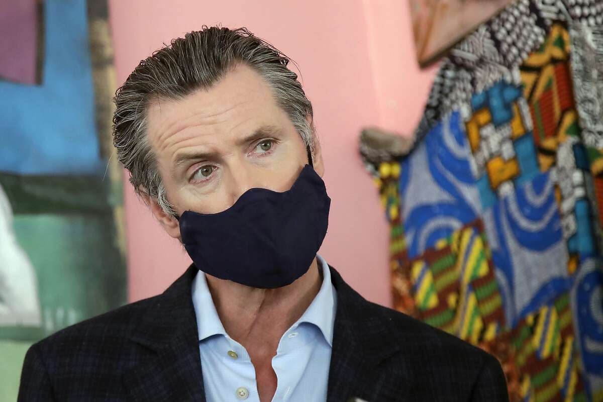FILE - In this June 9, 2020, file photo, California Gov. Gavin Newsom wears a protective mask on his face while speaking to reporters at Miss Ollie's restaurant during the coronavirus outbreak in Oakland, Calif.