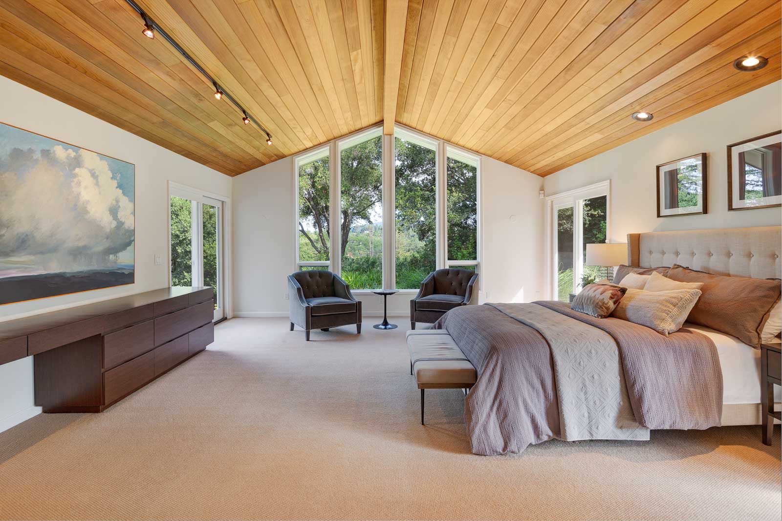 The master suite features dramatic windows framing views of the southwestern hills, a library/den/study, and a private deck.