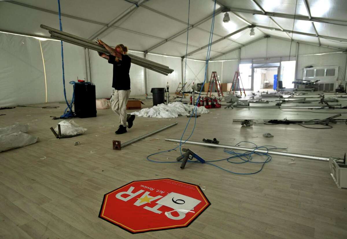 Workers dismantle a temporary field tent outside Bridgeport Hospital in Bridgeport, Conn. on Monday, June 15, 2020. Set up at the height of the COVID-19 pandemic, the tent featured over 30 beds for non-COVID patients. The hospital's COVID cases have decreased from a high of 220 on April 18 to only 30 currently.
