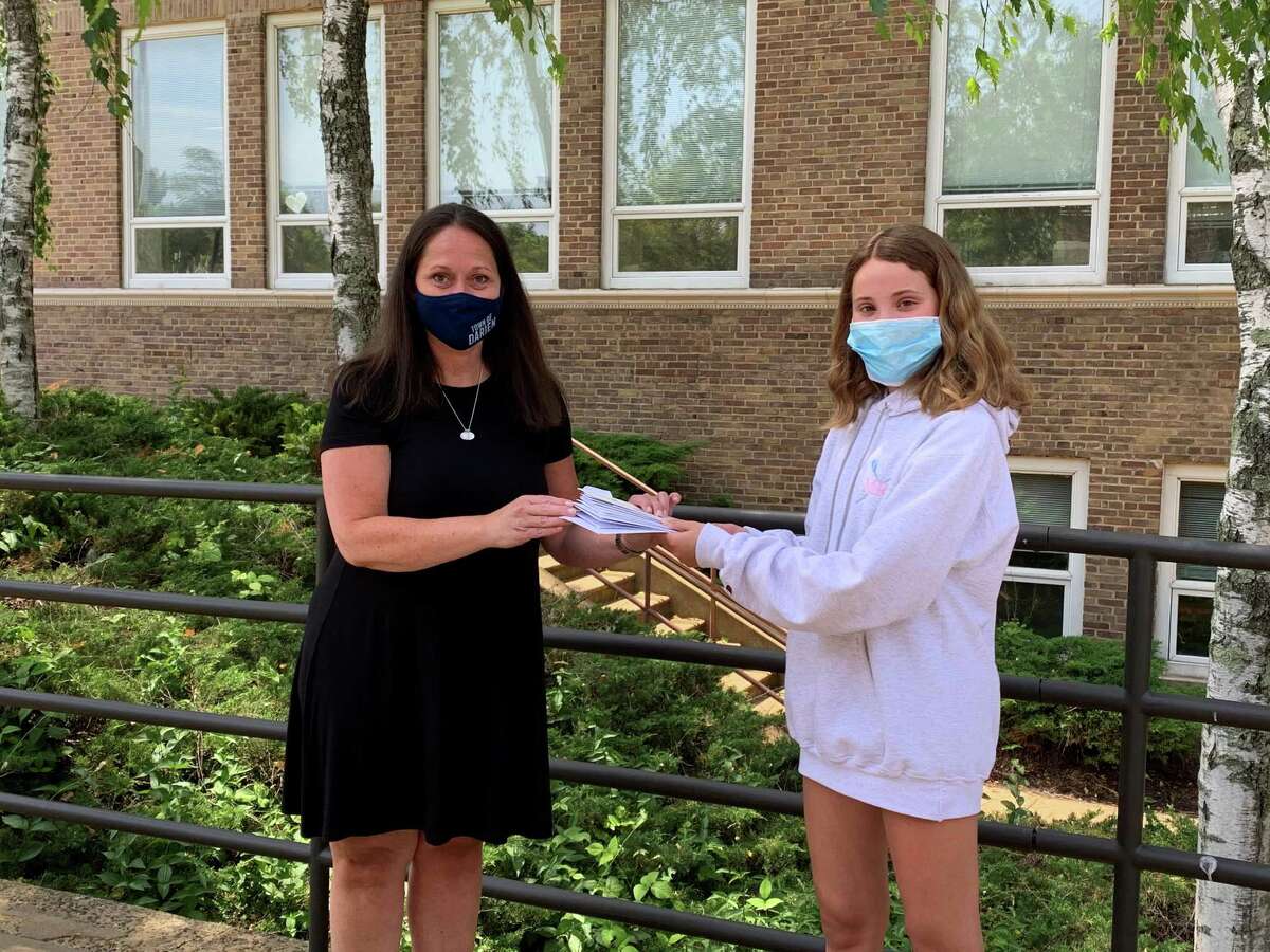 From left, Ali Ramsteck, director of Darien Human Services, is receiving donations of free gift certificates that have been donated through Rescue Main Street Darien, a gift card swap created by teen Sophie Curtis, right.
