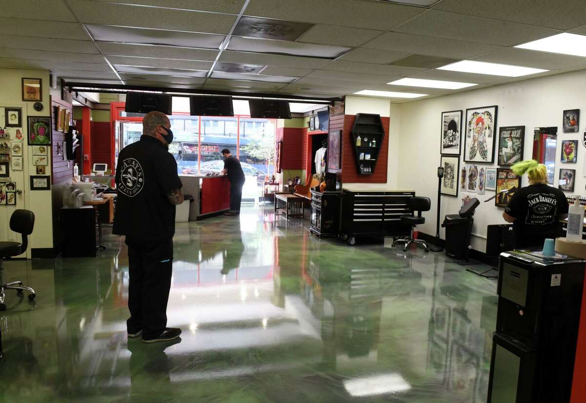 William Yager III, proprietor of Albany Modern Body Art, Tattoos and Piercing, left, walks through his shop on South Pearl Street during the first day of reopening under the state's phase three coronavirus plan on Wednesday, June 17, 2020, in Albany, N.Y. Capital Region tattoo parlors were able to open on Wednesday under coronavirus safety guidelines. (Will Waldron/Times Union)