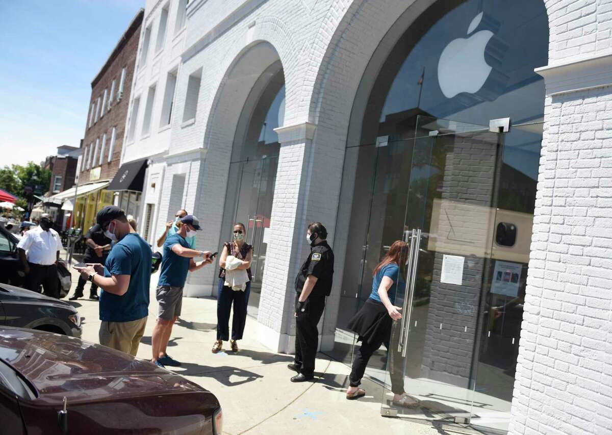 Customers enter the Apple store on the day of its reopening in Greenwich, Conn. Wednesday, June 17, 2020. The Apple Store reopened with other businesses of the second phase of reopenings in Connecticut, including nail salons, gyms, limited indoor dining, pools, tattoo parlors and more.