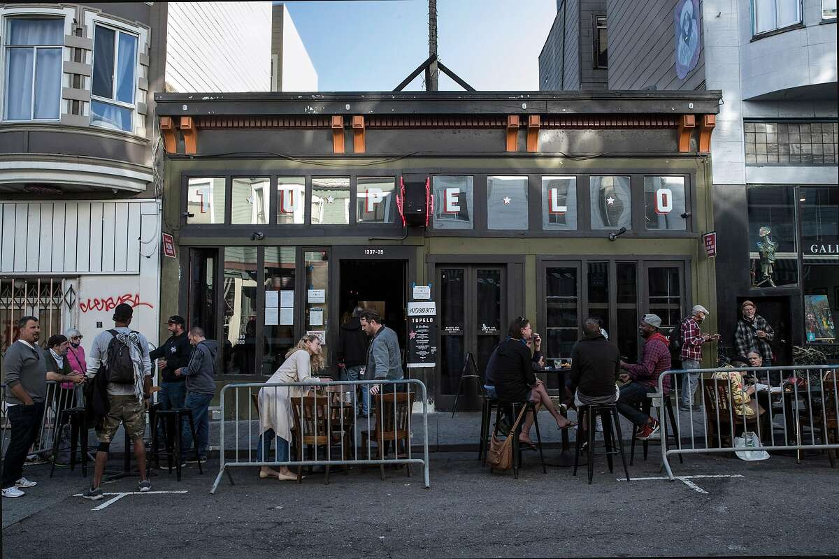 Guests gather at outdoor tables at Tupelo in San Francisco, Calif., on Tuesday, June 16, 2020. The transitional post-shelter in place phase of landscape of San Francisco dining establishments is starting. Eateries try to stir back into action, but with a burden of constraints of protecting their customers. Several places on Belden Place are coming back with spaced outdoor tables, and several places on Green Street between Grant and Columbus are testing the waters as well with new dining in the street.