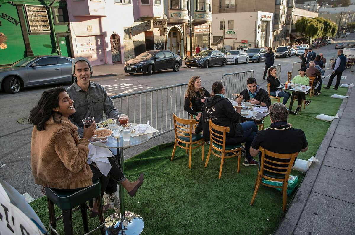 Diners at Sodini's Green Valley Restaurant at their outdoor tables on synthetic grass in San Francisco, Calif., on Tuesday, June 16, 2020. The transitional post-shelter in place phase of landscape of San Francisco dining establishments is starting. Eateries try to stir back into action, but with a burden of constraints of protecting their customers. Several places on Belden Place are coming back with spaced outdoor tables, and several places on Green Street between Grant and Columbus are testing the waters as well with new dining in the street.