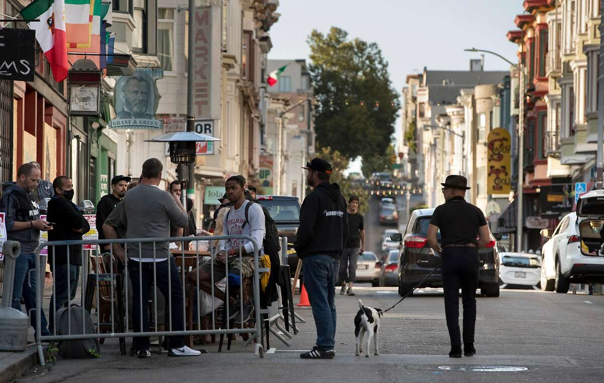 Guests gather at outdoor tables at Tupelo on Grant Avenue in San Francisco, Calif., on Tuesday, June 16, 2020. While some businesses have been allowed to open with restrictions, the planned expansion of reopening set for Monday has been delayed by the city.