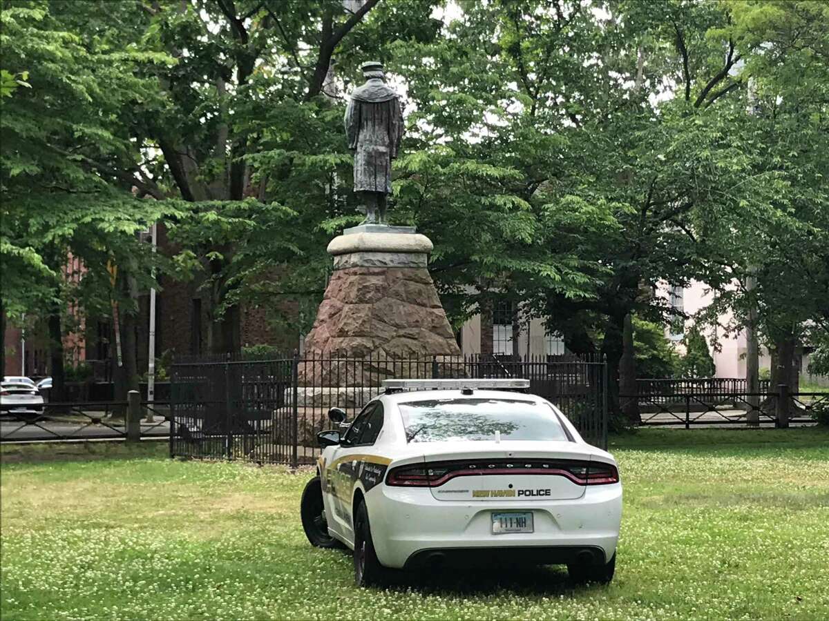 A New Haven Police Department cruiser is stationed near the statue of Christopher Columbus in Wooster Square Park on June 15, 2020.