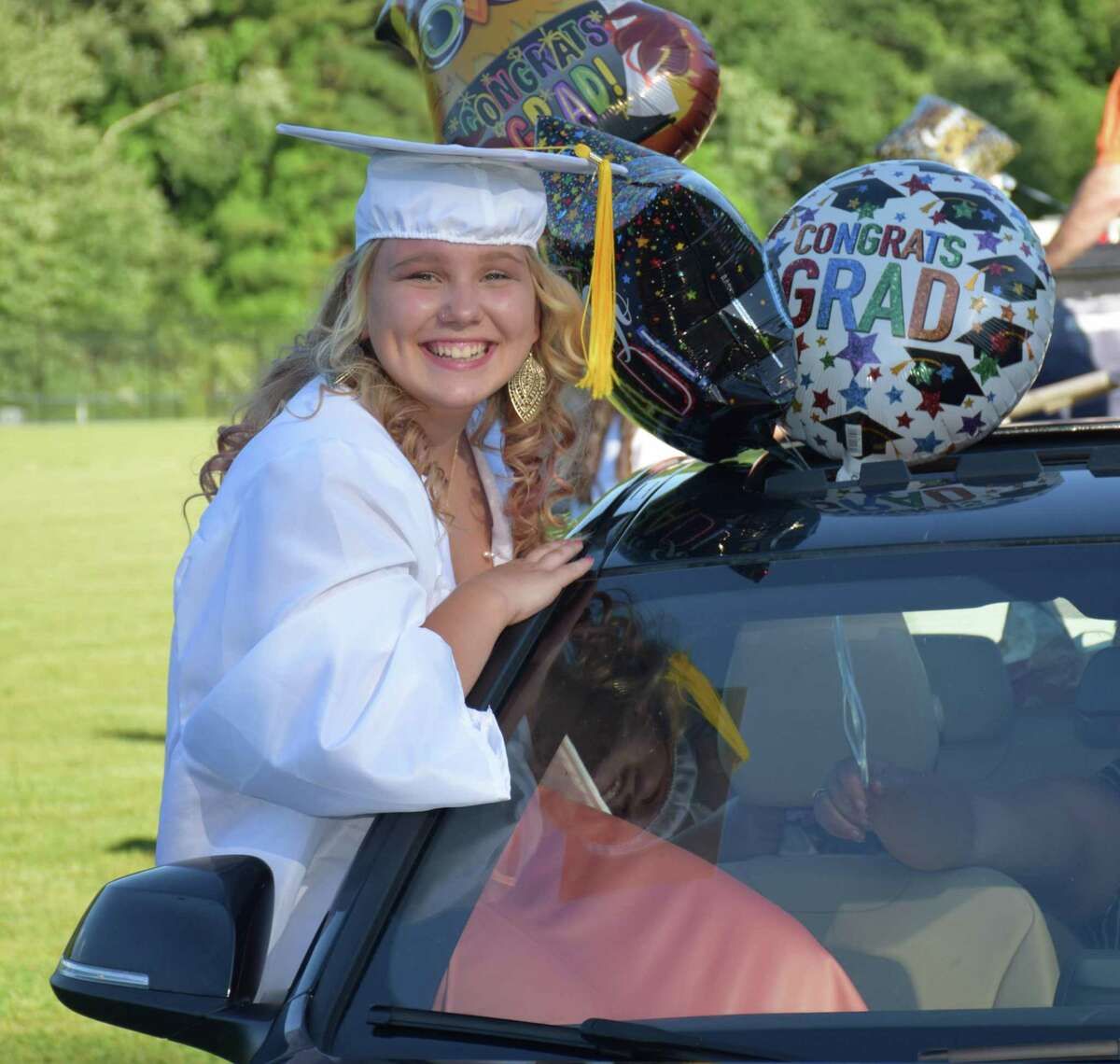 Sherman School held its eighth-grade graduation ceremony Saturday at Veterans Field. Students and their families arrived in a vehicle and parked in designated spots in the the field, where a ceremony was held adhering to social distancing guidelines. The majority of the cars were decorated. Above, Tijana Kanacki proudly awaits the start of the ceremony, joining fellow graduates by taking a creative seat in a vehicle. For more photographs, see Page S9.